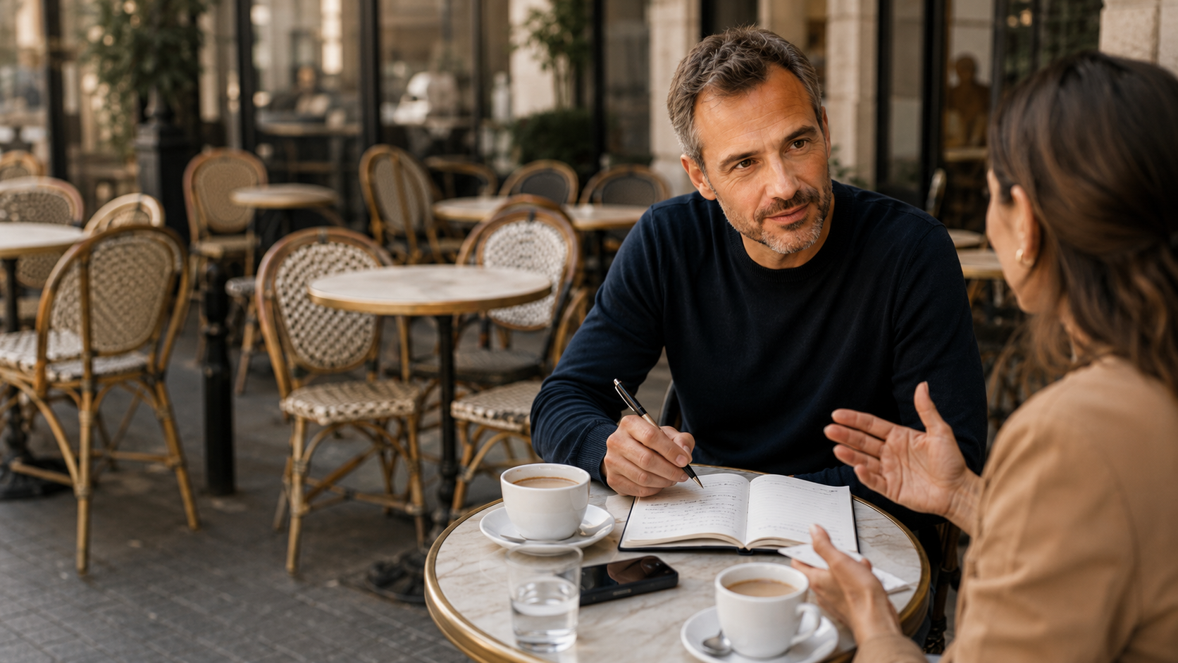 Homme de 42 ans menant un entretien avec une cible dans un café pour tester son idée d’entreprise et mieux comprendre son marché.